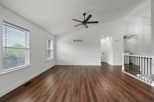 Spare room featuring ceiling fan, visible vents, dark wood-style floors, and lofted ceiling | Image 21