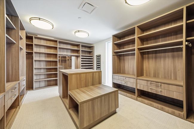Custom designed closet with a thoughtful design and a center storage and packing counter. | Image 20