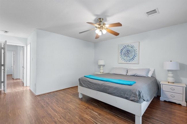 Bedroom featuring wood finished floors, visible vents, and a ceiling fan | Image 20