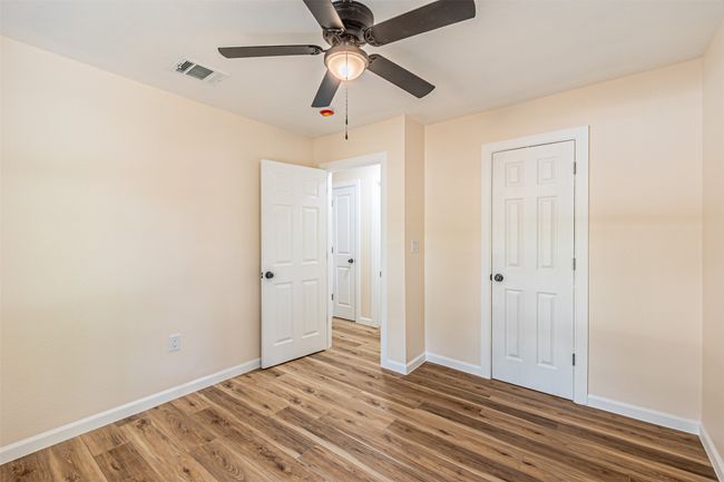 Unfurnished bedroom featuring baseboards, a ceiling fan, wood finished floors, and visible vents | Image 22