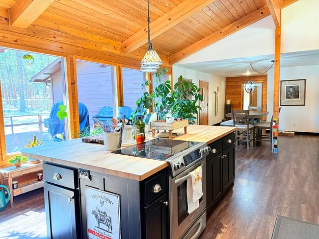 Kitchen featuring butcher block island counters, stainless steel range with electric range and a wealth of natural light | Image 13