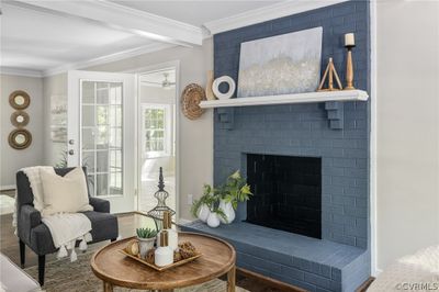 Family room featuring beam ceiling, dark hardwood flooring, and a brick fireplace | Image 1