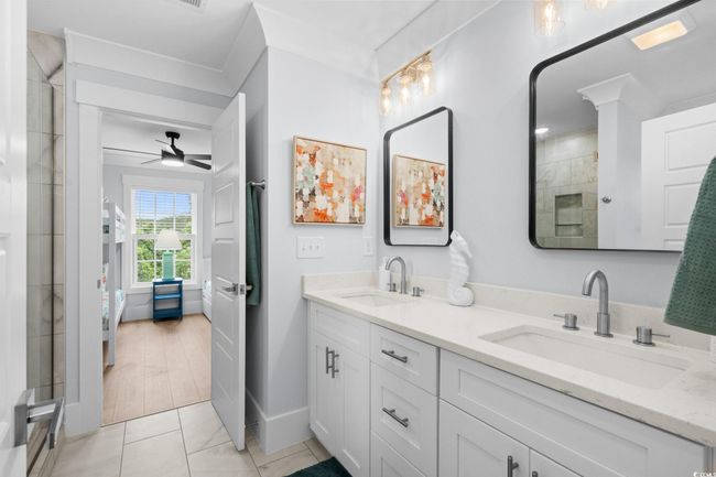 Ensuite bathroom with double vanity, a stall shower, light tile patterned floors, and a ceiling fan | Image 18