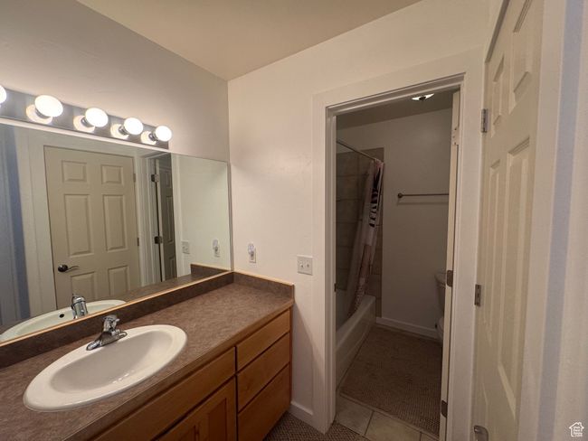 Full bathroom featuring vanity, light tile patterned flooring, and shower / bathtub combination with curtain | Image 11