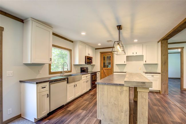 Kitchen with stainless steel appliances, dark countertops, recessed lighting, and white cabinets | Image 15