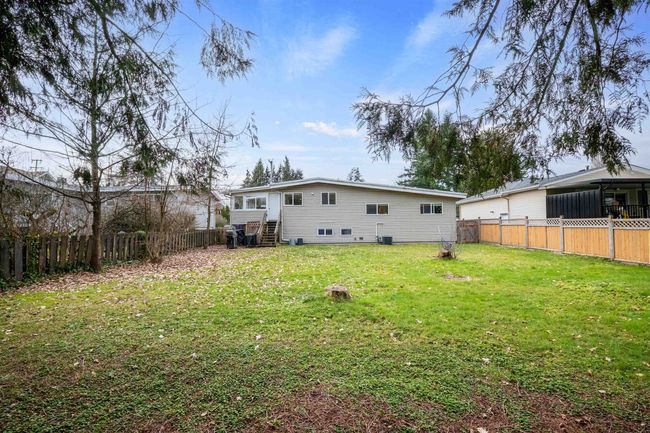 Rear view of property featuring a lawn, entry steps, and a fenced backyard | Image 15