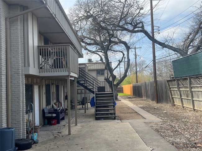 View of side of home featuring a patio, stairway, and fence | Image 13