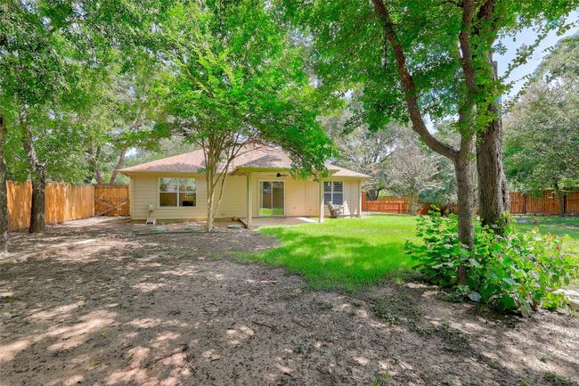Rear view of house featuring a patio area, a fenced backyard surrounded by trees | Image 28
