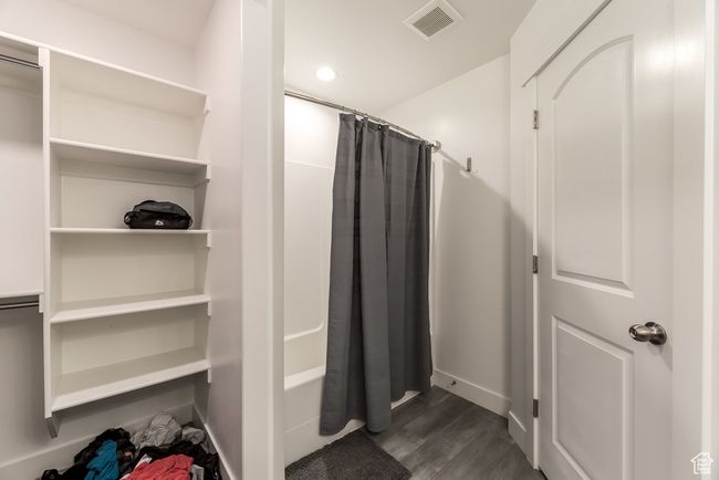 Full bath featuring shower / bath combo, visible vents, baseboards, and wood finished floors | Image 15