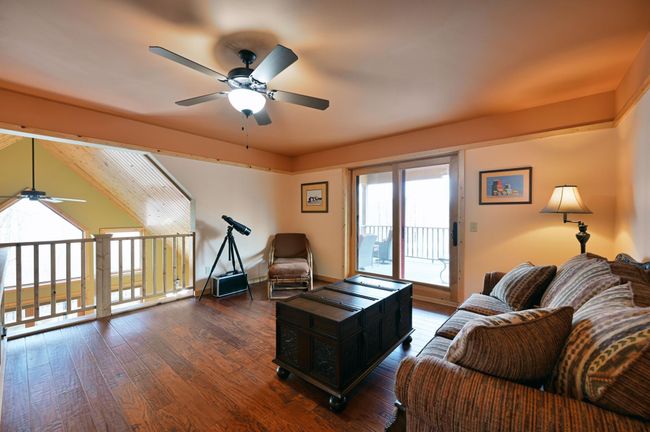 The open loft is a great flex space. It has a ceiling fan with sliding doors going out to another deck. | Image 31