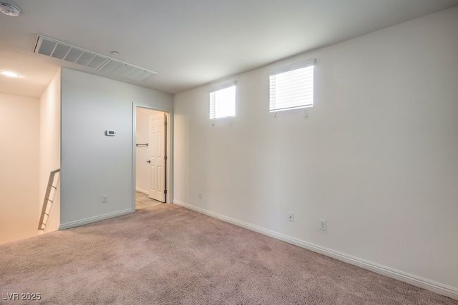 Below grade area with light carpet, visible vents, and baseboards | Image 24