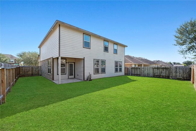 Completely level green, the backyard is shaped for playing and gardening. | Image 40