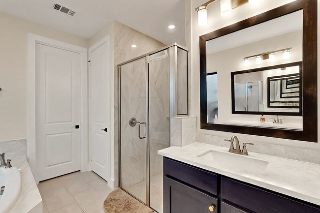 Bathroom featuring a shower stall, a garden tub, tile patterned floors, and vanity | Image 21