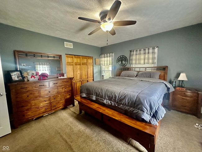 bedroom featuring light colored carpet, a ceiling fan, and a closet | Image 26