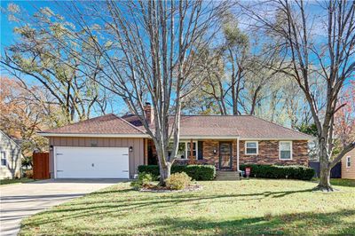 Ranch-style house featuring a front lawn and a garage | Image 1