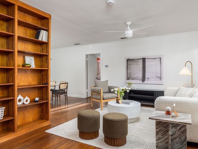 Living room with a ceiling fan, wood flooring, and built in shelves | Image 6