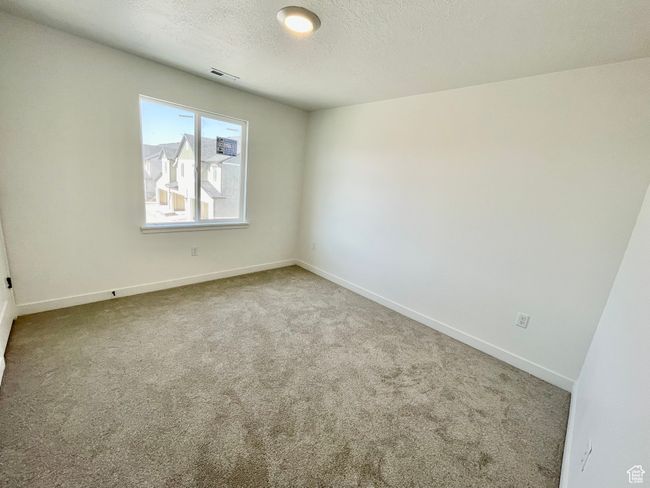 Carpeted empty room featuring baseboards and a textured ceiling | Image 16