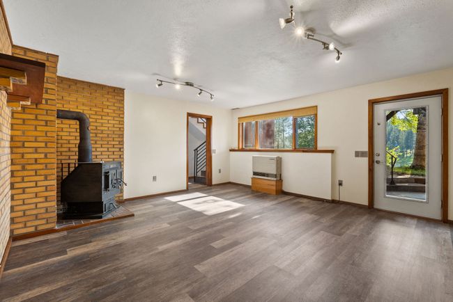 Lower level second living space with walkout to patio & wood stove | Image 35