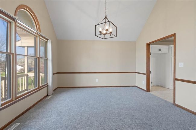Empty room featuring a wealth of natural light, vaulted ceiling, and light carpet | Image 34