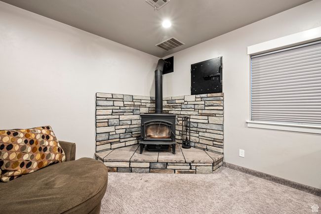 Carpeted living area with visible vents and a wood stove | Image 37