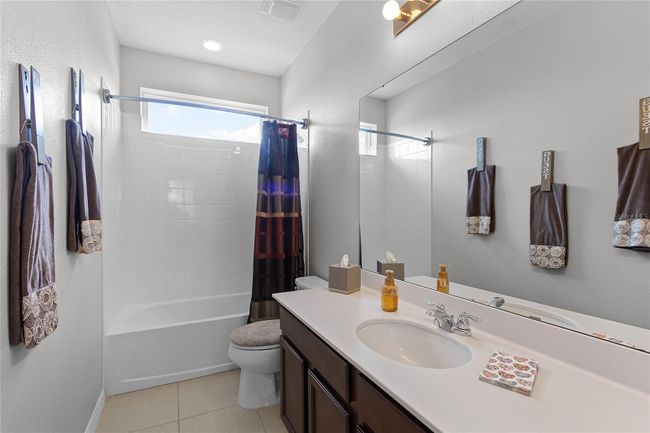 full bath with a large vanity and a tub with a shower. | Image 31