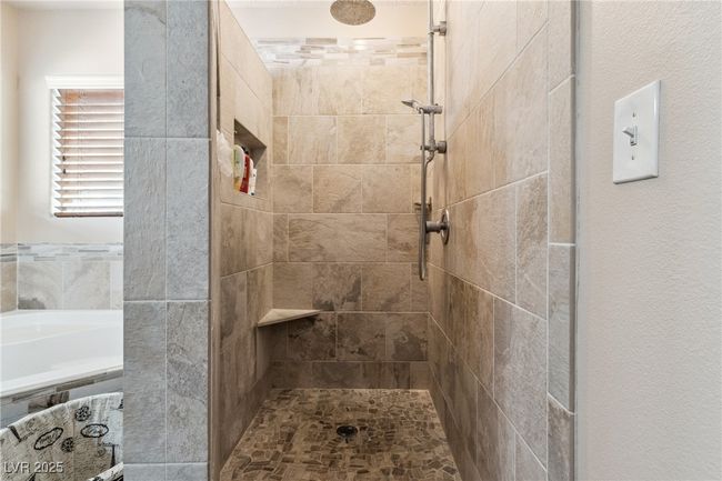 Bathroom featuring a tile shower and a garden tub | Image 33