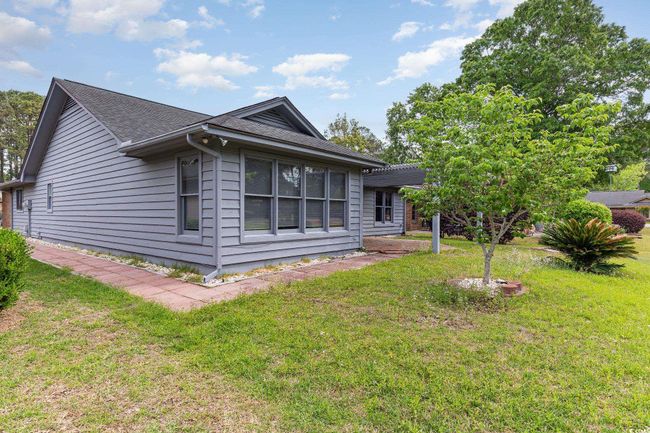 View of property exterior featuring a yard and a shingled roof | Image 30