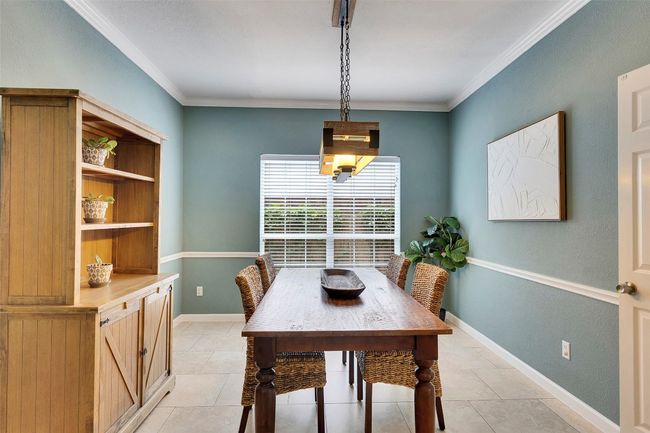 Dining room featuring ornamental molding, light tile patterned floors, and baseboards | Image 6