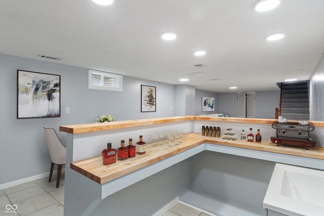 indoor bar with stairs, baseboards, and recessed lighting | Image 36