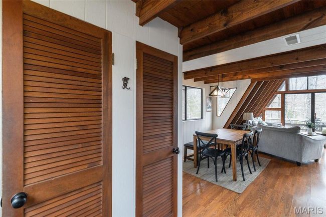 Dining area featuring beam ceiling and wood finished floors | Image 21