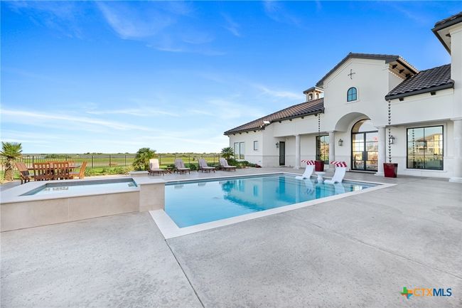 Pool - Heated and Chilled with Tanning Ledge and Perimeter Seating, Hot Tub, and Poolside Seating Area | Image 32