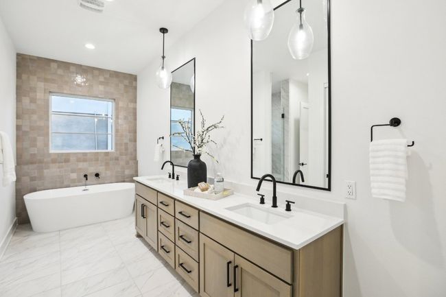 Indulge in spa-level comfort with a deep soaking tub and oversized walk-in shower. | Image 4