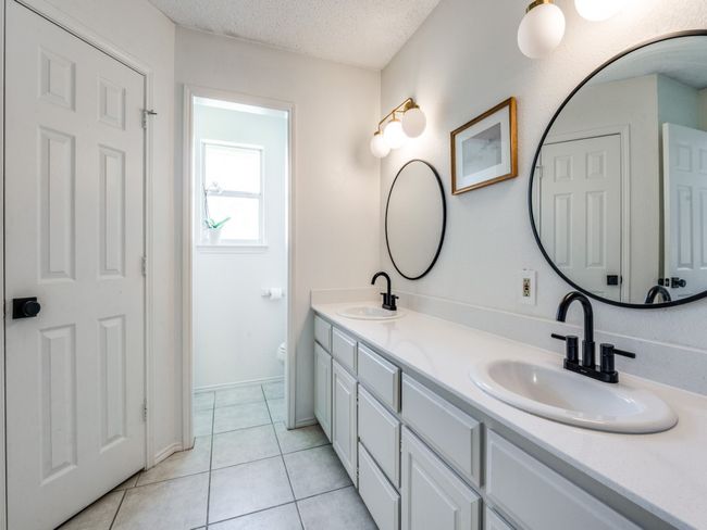 Bathroom with double vanity, a textured ceiling, and tile patterned floors | Image 23