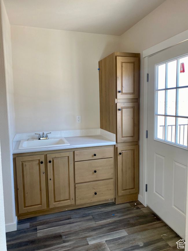 Kitchen with light brown cabinets, dark wood-type flooring, and light countertops | Image 12