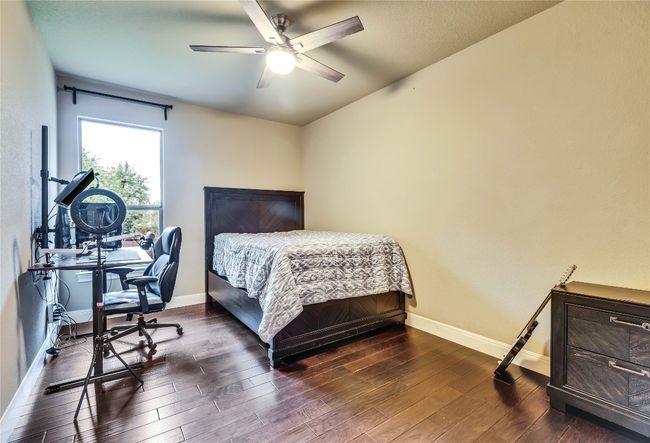 Bedroom with dark wood-style floors and ceiling fan | Image 12
