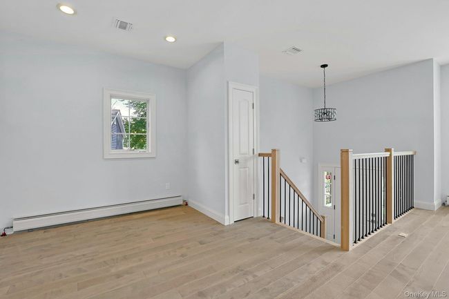 Dining room with light wood-type flooring, a baseboard heating unit, a chandelier, and recessed lighting | Image 5