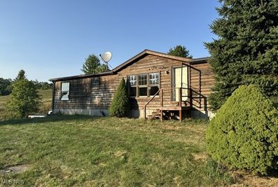 Rear view of house with a yard and a shed | Image 1