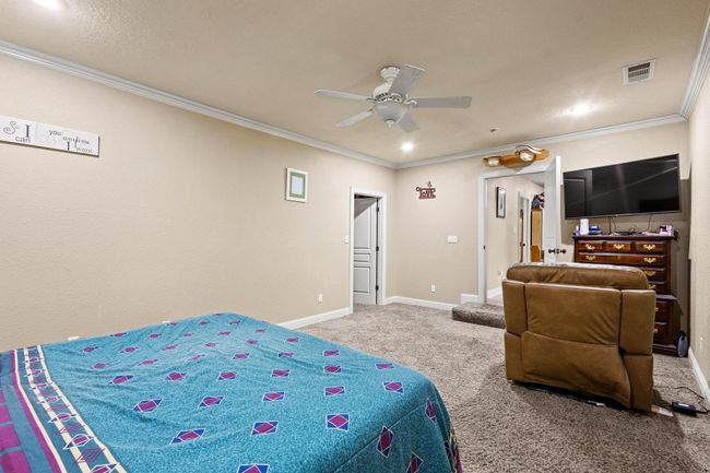Bedroom with visible vents, carpet flooring, baseboards, and ornamental molding | Image 21