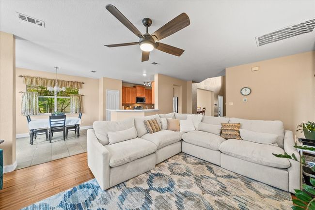 Living area featuring light wood-type flooring, ceiling fan, and baseboards | Image 18