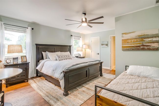 Bedroom featuring a ceiling fan, crown molding, visible vents, and light wood finished floors | Image 28