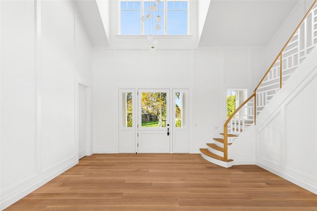 Entryway featuring custom designed staircase and railing w catherdral ceiling and chandelier | Image 4