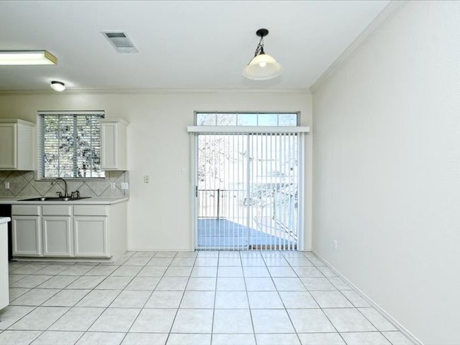 Kitchen featuring crown molding, a sink, tasteful backsplash, light tile patterned floors, and visible vents | Image 7