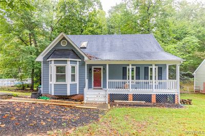 View of front of home with a front lawn and a porch | Image 1