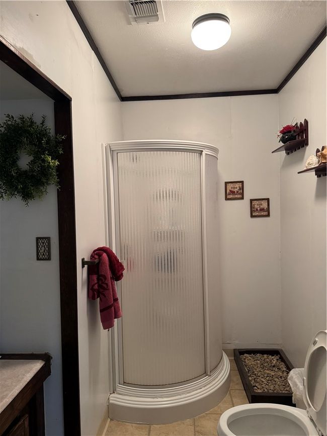 Bathroom with a shower stall, toilet, and tile patterned floors | Image 15