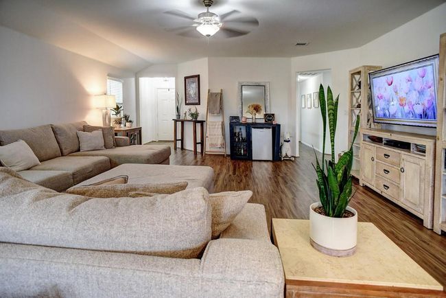Living area featuring dark wood-style flooring, visible vents, and ceiling fan | Image 7