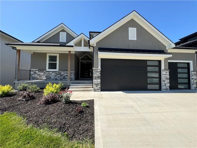 View of front of property with stone siding, stucco siding, and a garage | Image 66