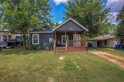 Bungalow-style home featuring a porch and a yard | Image 1