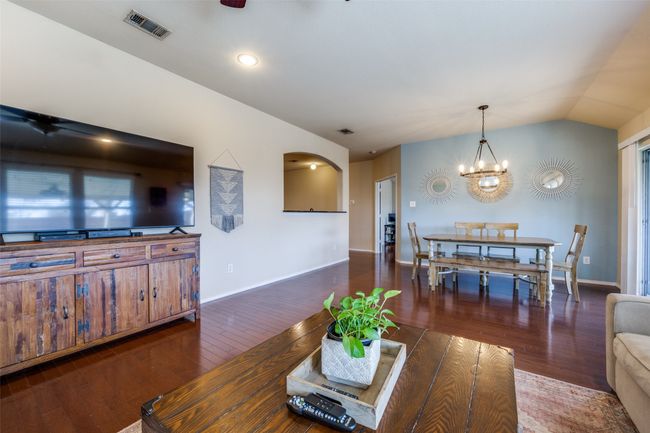 Living area featuring a chandelier, wood finished floors, and vaulted ceiling | Image 16