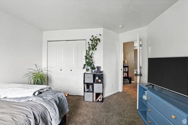 Bedroom featuring dark carpet and a closet | Image 23