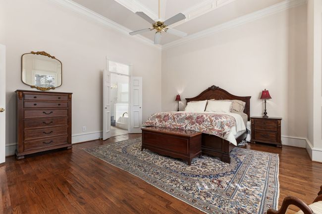 Bedroom with a ceiling fan, crown molding and wood finished floors | Image 19